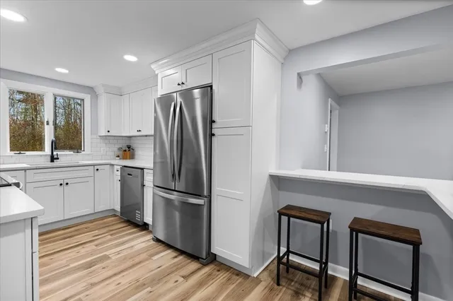 a kitchen with white cabinets and stainless steel appliances