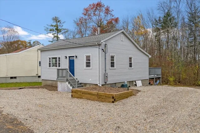 a view of a small house with a yard and garage