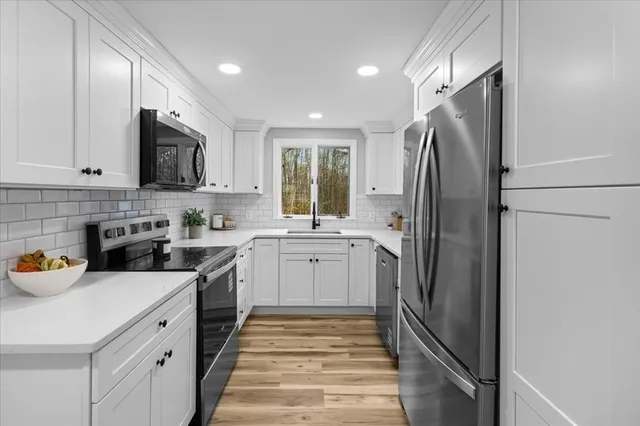 a kitchen with a sink stainless steel appliances and cabinets