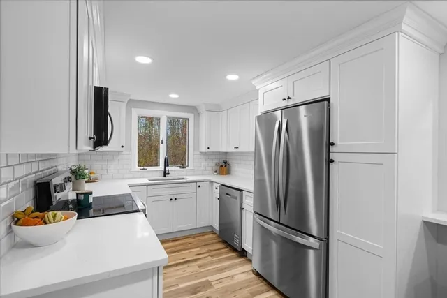a kitchen with white cabinets and stainless steel appliances
