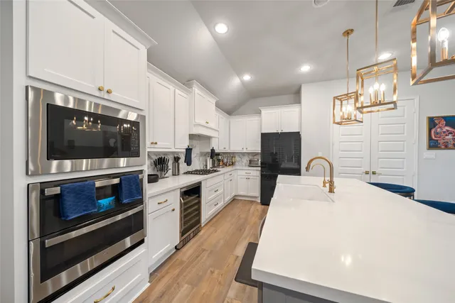a kitchen with stainless steel appliances a stove sink microwave and cabinets