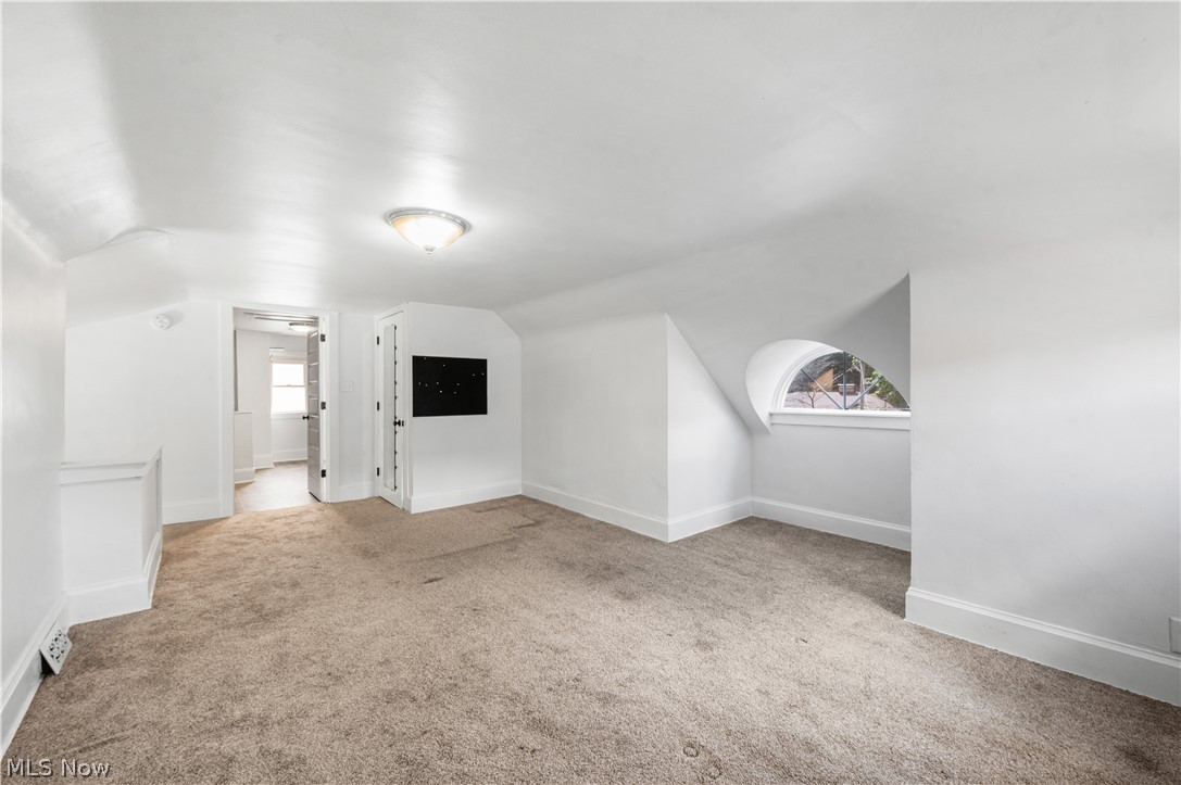 371 Merriman Road Akron, OH 44303 - Photo 24 of 27 Carpeted room with a vaulted ceiling, illuminated by a flush-mount light fixture
