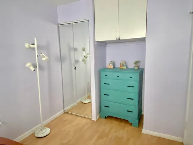 a bedroom with a bed and painting on the wall