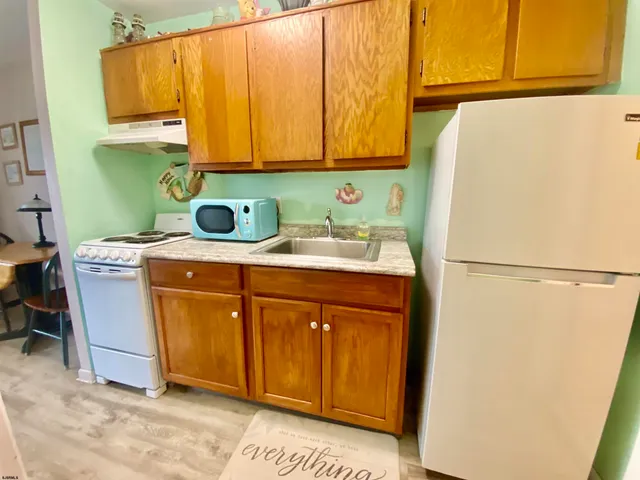 a utility room with a refrigerator and washer