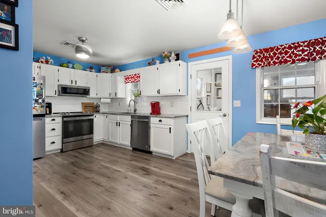 a kitchen with granite countertop a white refrigerator sink and cabinets