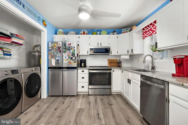 a kitchen with granite countertop a sink stainless steel appliances and cabinets
