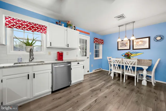 a dining room with furniture a chandelier and wooden floor