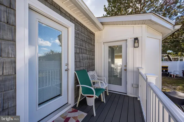 a backyard of a house with table and chairs under an umbrella