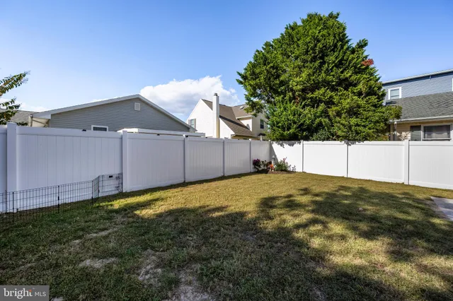 a view of a house with a wooden deck and a yard