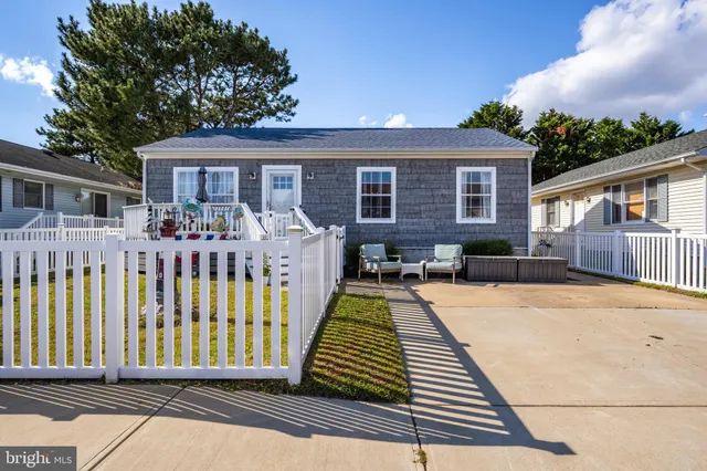 a front view of house with yard seating and barbeque oven