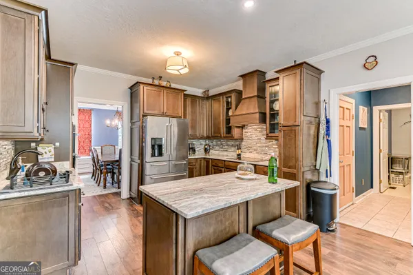 a kitchen with a table chairs refrigerator and cabinets
