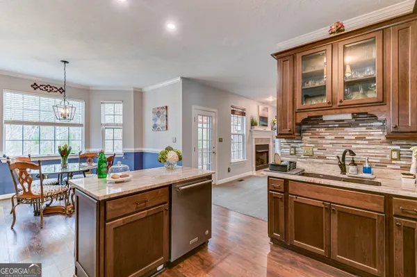 a kitchen with stainless steel appliances granite countertop a sink stove and wooden cabinets