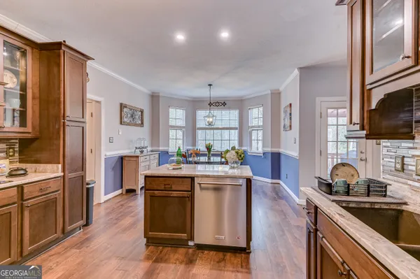 a kitchen with kitchen island granite countertop a sink appliances cabinets and a counter top space