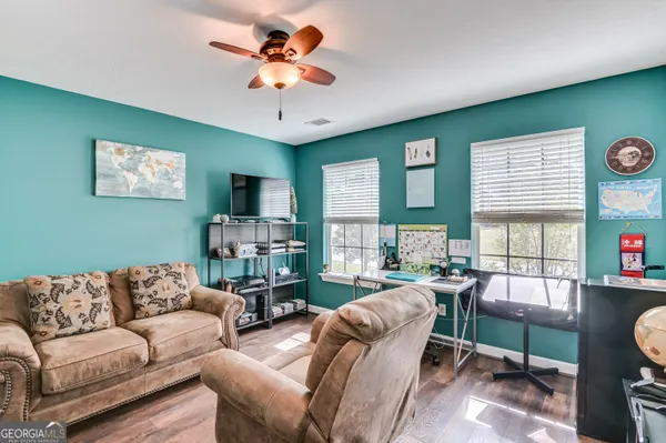 a living room with furniture a flat screen tv and a large window