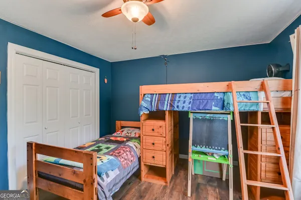 a bedroom with a bed and wooden floor
