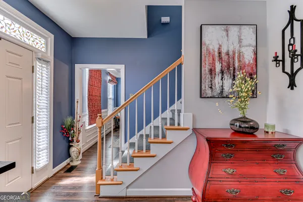 a view of a hallway with wooden floor and stairs