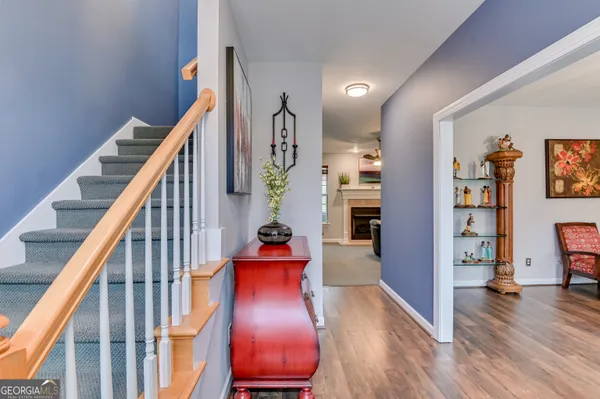 a view of a hallway with wooden floor and stairs