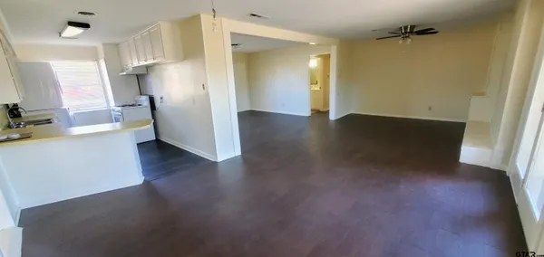 a view of a hallway with wooden floor and a bathroom