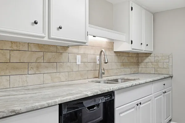 a kitchen with granite countertop a sink and cabinets