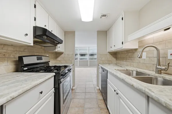 a kitchen with stainless steel appliances granite countertop a sink stove and cabinets