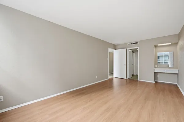 an empty room with wooden floor and windows