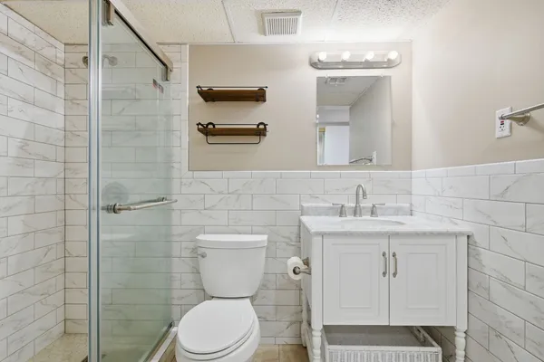 a bathroom with a toilet a sink and mirror