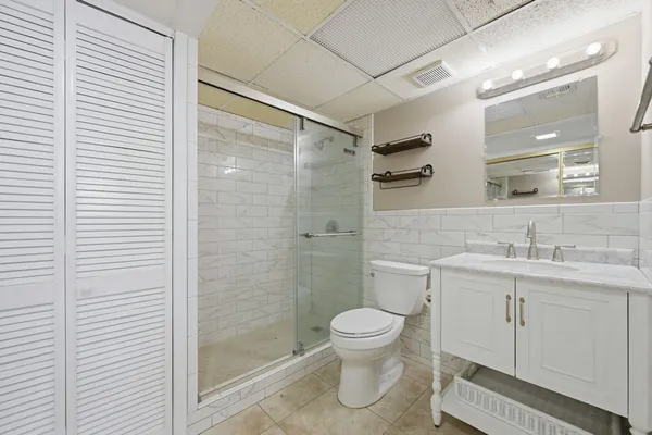a bathroom with a toilet sink vanity and shower