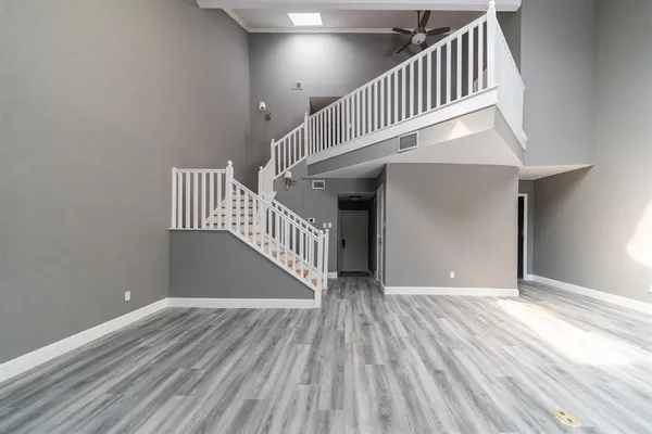 a kitchen with granite countertop a refrigerator and white cabinets