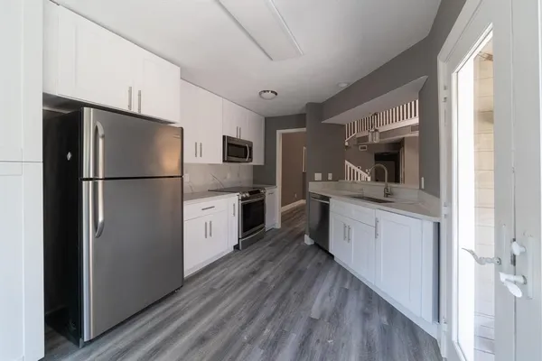 a kitchen with white cabinets stainless steel appliances and sink