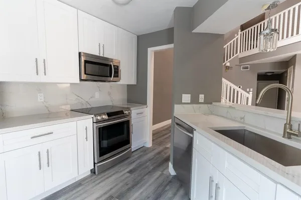 a kitchen with kitchen island granite countertop a sink and a stove top oven