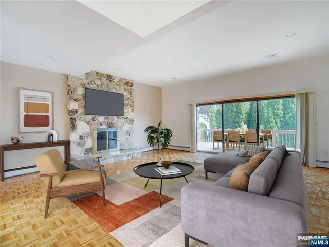 a living room with furniture a flat screen tv and a large window