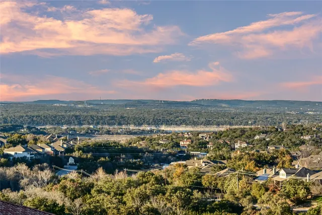 an aerial view of residential houses with yard and mountain view in back