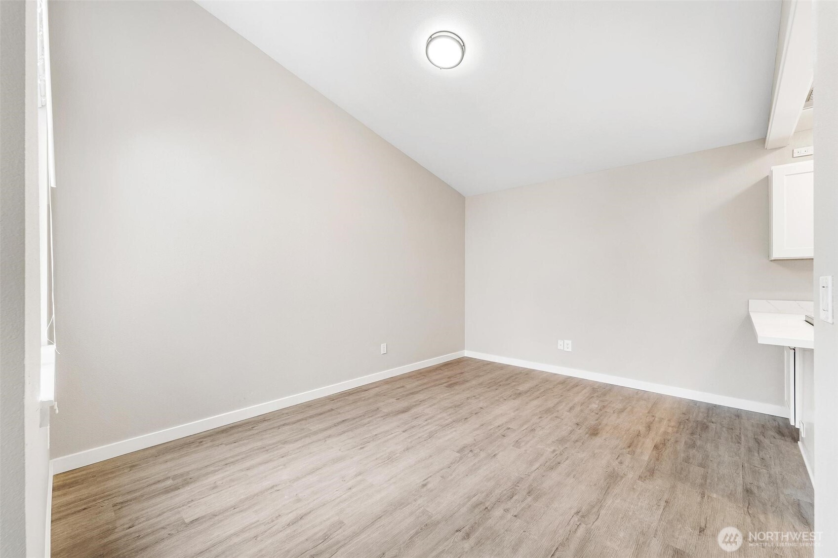 604 213th Street Southwest Bothell, WA 98021 - Photo 11 of 40 a view of an empty room with wooden floor and a window