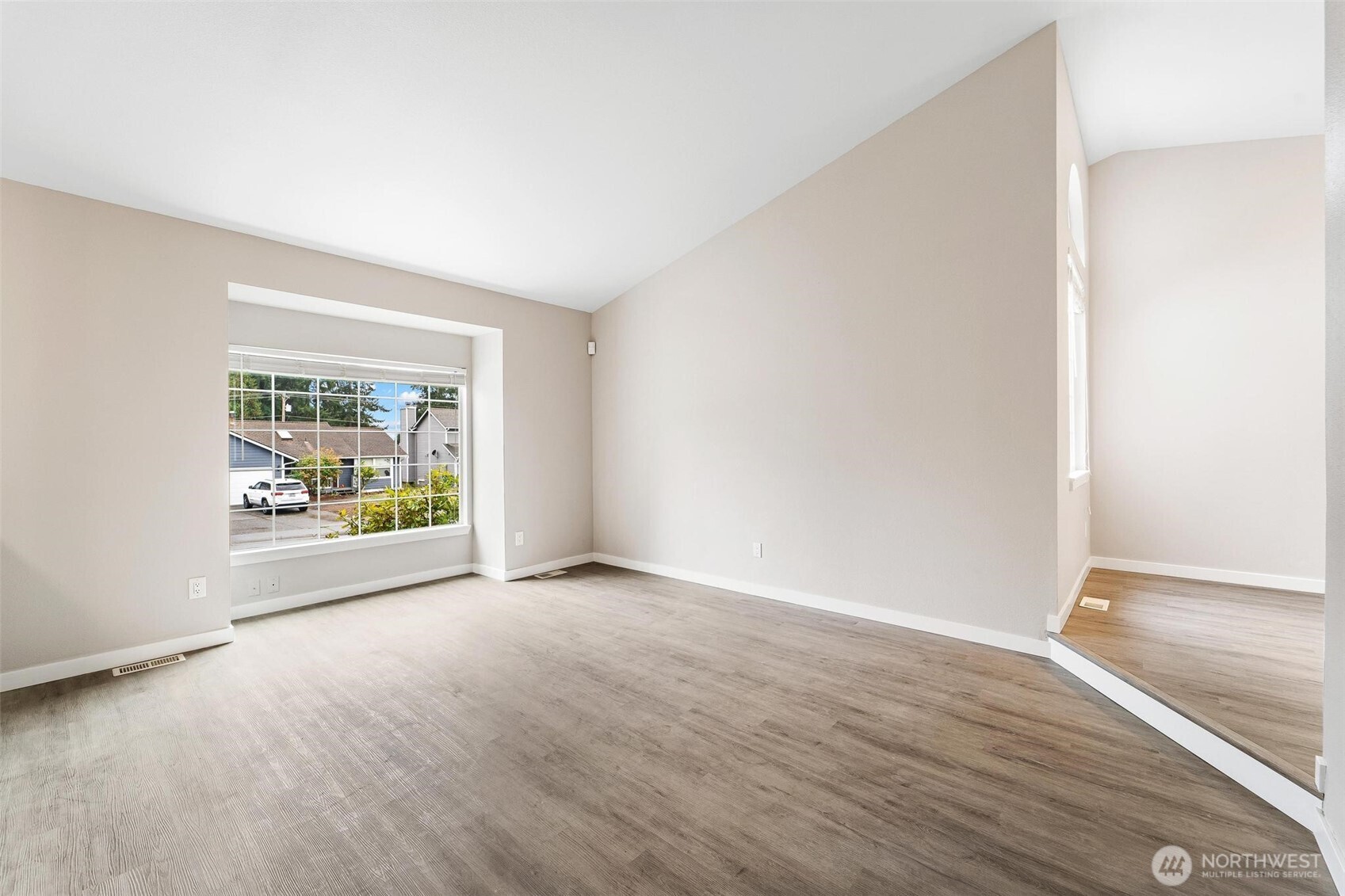604 213th Street Southwest Bothell, WA 98021 - Photo 9 of 40 an empty room with wooden floor and windows