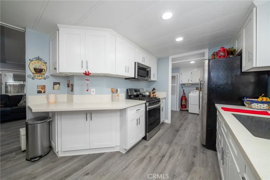 4000 Pierce Street, Unit 58 Riverside, CA 92505 - Photo 14 of 32 a kitchen with refrigerator cabinets and wooden floor