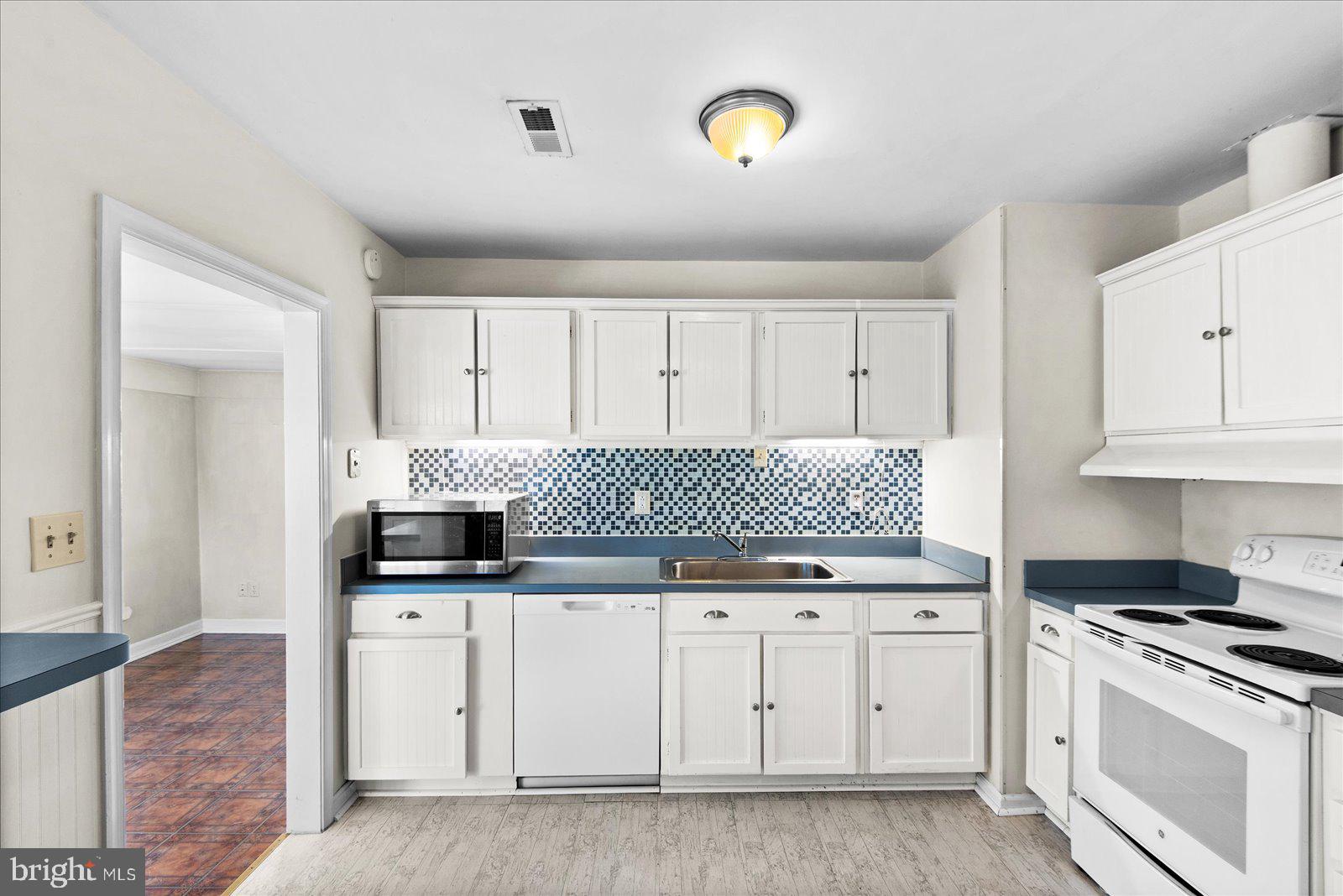 227 7th Street Colonial Beach, VA 22443 - Photo 11 of 36 a kitchen with granite countertop white cabinets and stainless steel appliances