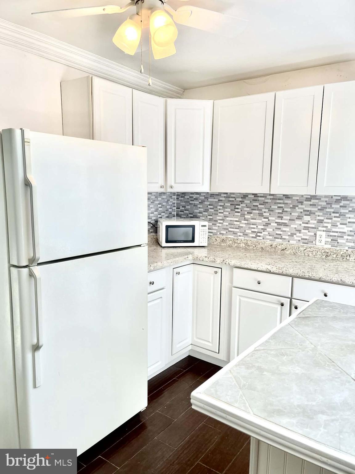 227 7th Street Colonial Beach, VA 22443 - Photo 24 of 36 a kitchen with a refrigerator a sink and cabinets