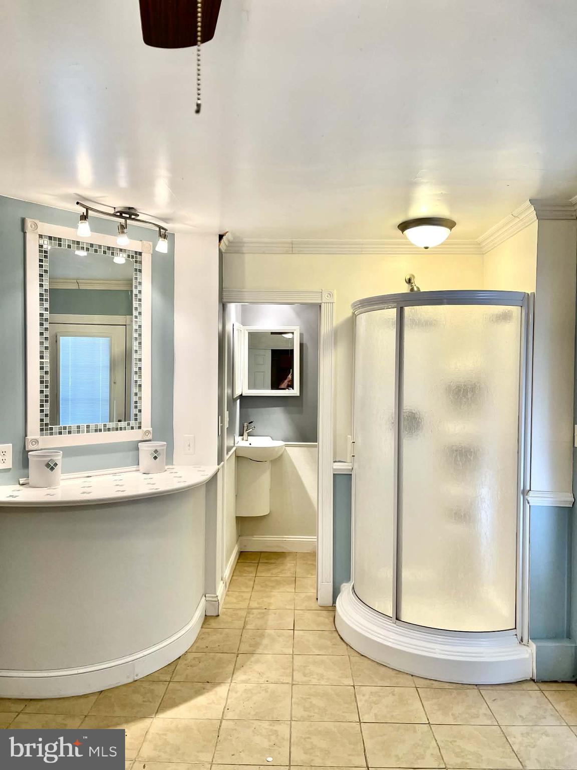 227 7th Street Colonial Beach, VA 22443 - Photo 31 of 36 a view of a bathroom with a tub shower and mirror
