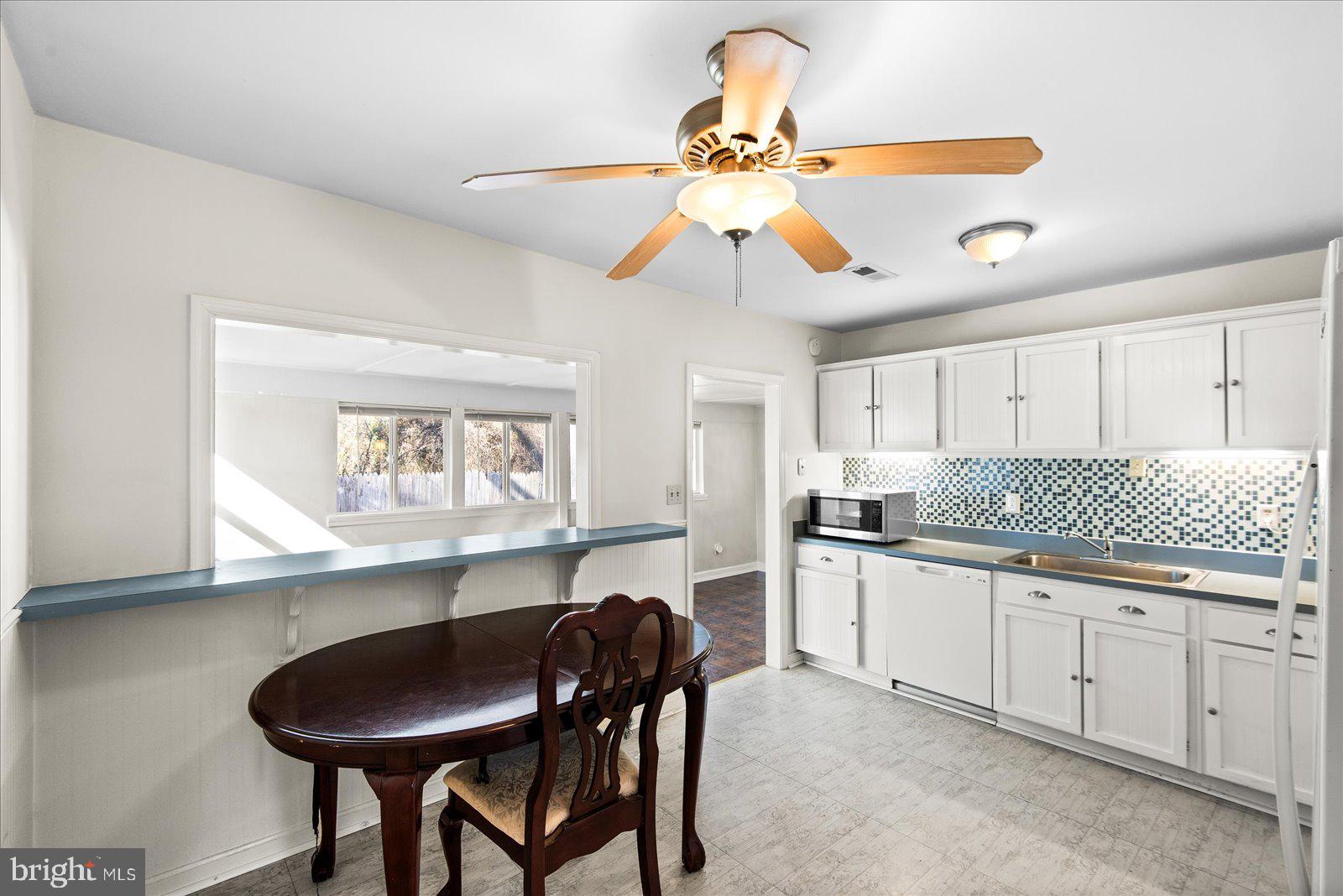 227 7th Street Colonial Beach, VA 22443 - Photo 10 of 36 a kitchen with stainless steel appliances a table and chairs