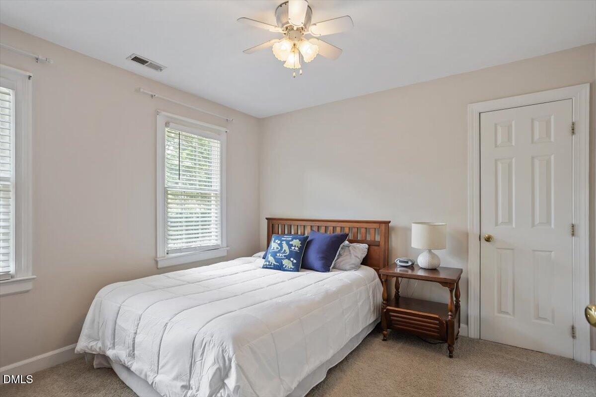 1808 Thorpshire Drive Raleigh, NC 27615 - Photo 13 of 17 a bedroom with a bed and a chandelier