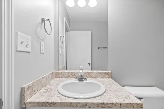 a bathroom with a granite countertop sink and a mirror