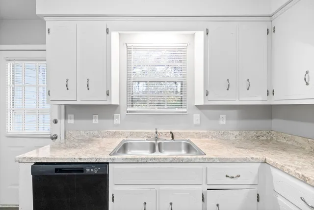 a kitchen with granite countertop white cabinets and a sink