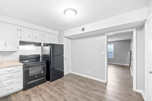 a kitchen with a refrigerator and a stove