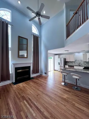 a view of kitchen livingroom with furniture wooden floor fireplace and window