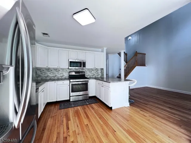 a kitchen with a refrigerator and white cabinets