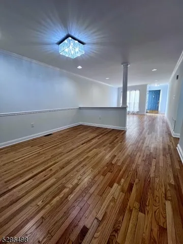 a view of a room with wooden floor and a ceiling fan