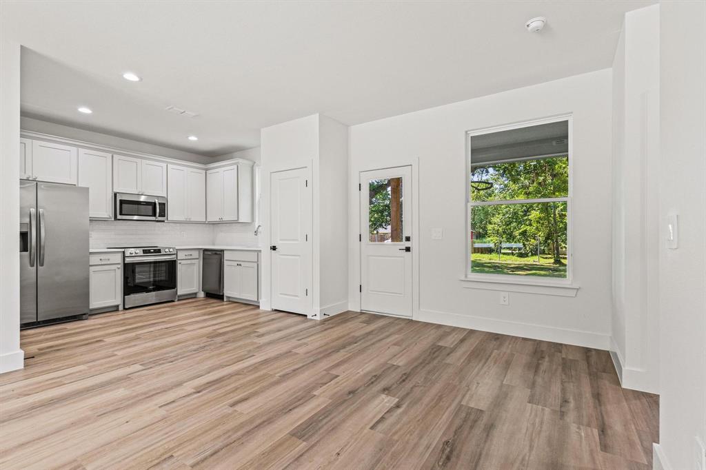 508 Florence Denison, TX 75020 - Photo 9 of 26 a view of a kitchen with wooden floor electronic appliances and window