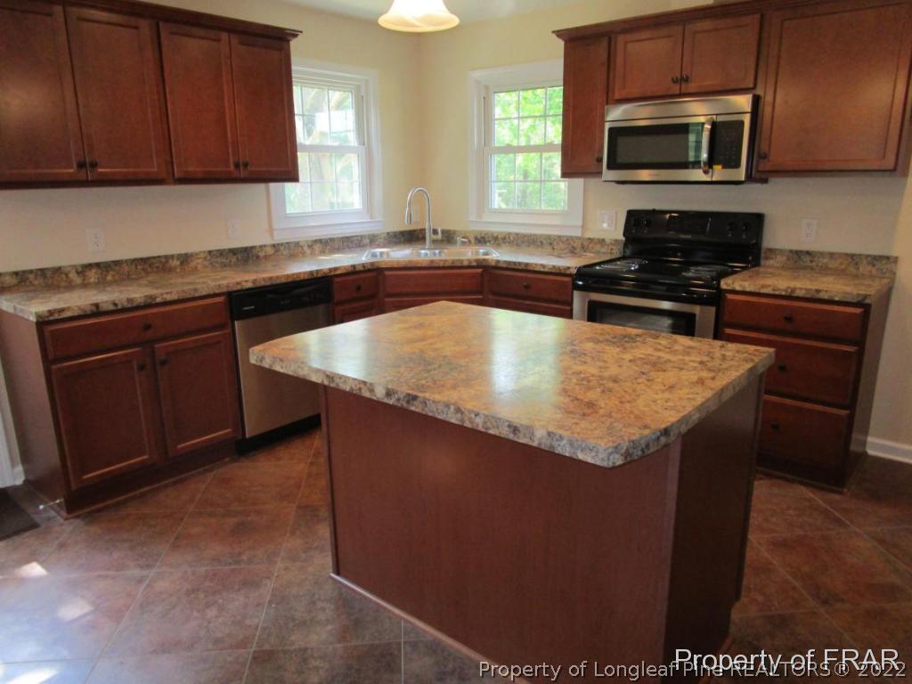 1373 Joel Road Carthage, NC 28327 - Photo 25 of 27 a kitchen with stainless steel appliances granite countertop a sink stove microwave and refrigerator