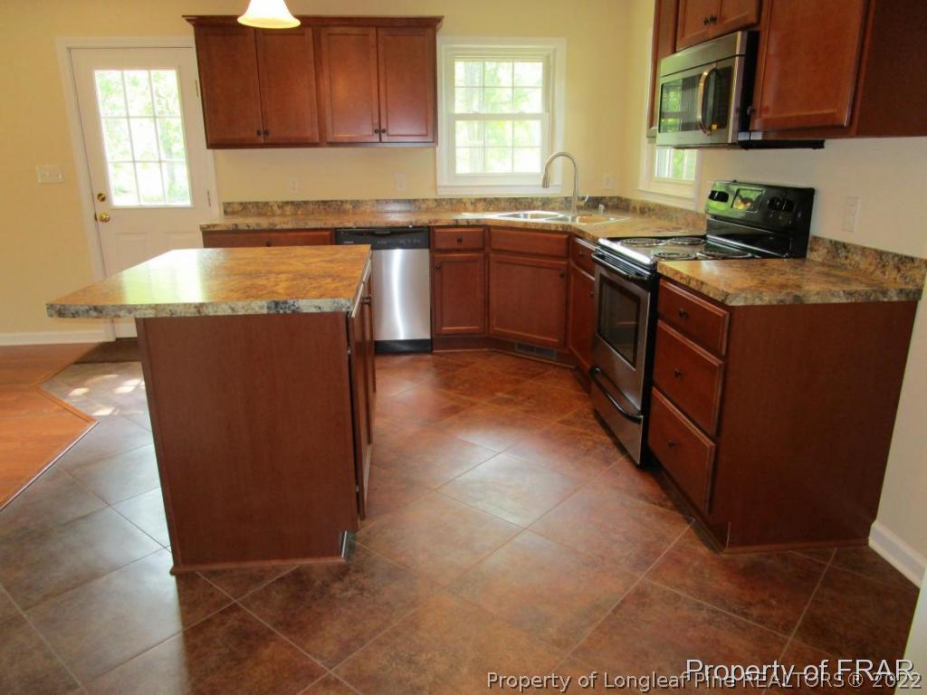 1373 Joel Road Carthage, NC 28327 - Photo 26 of 27 a kitchen with stainless steel appliances granite countertop a stove a sink and a microwave