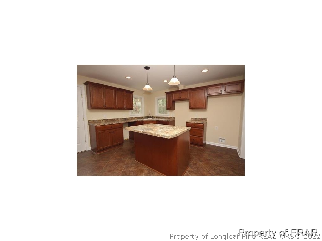 1373 Joel Road Carthage, NC 28327 - Photo 6 of 27 a kitchen with a sink and a stove with a hallway